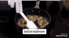 a person is stirring mushrooms in a pan on a stove .