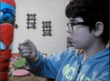 a boy wearing glasses and a blue sweatshirt with the letter c on the front