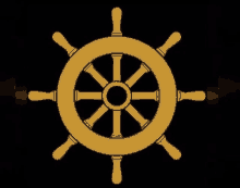 a gold ship steering wheel with a black background .