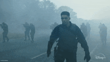 a man in a military uniform stands in front of a group of soldiers with a disney logo in the background