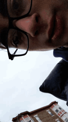 a man wearing glasses is looking down at something