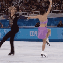 a man and a woman are ice skating in front of a sign that says ' сочи ' on it