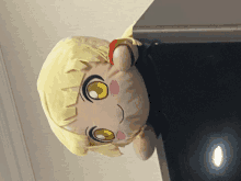 a stuffed doll with a yellow hair and yellow eyes is hanging upside down