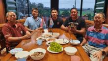 a man wearing a united states shirt sits at a table with his friends