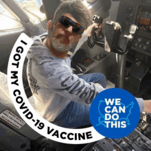 a man is sitting in a cockpit with a sticker that says i got my covid-19 vaccine