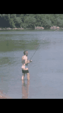 a man is fishing in a lake with a fishing rod