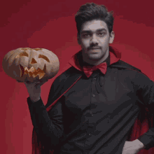 a man in a vampire costume holds a carved pumpkin with the words fangs for being a bloody good friend below him