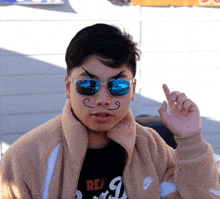 a boy wearing sunglasses and a nike jacket has a face drawn on his face