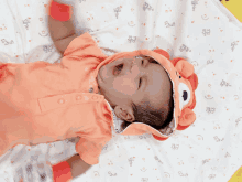 a baby wearing a lion costume is laying on a bed