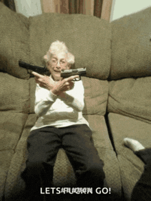 an elderly woman sitting on a couch holding a gun with the words let 's # # # # # # go below her