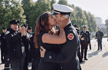 a man in a chicago fire department uniform kisses a woman in front of a crowd of firefighters