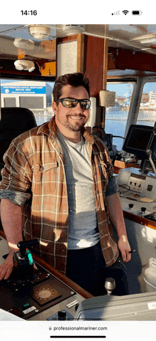 a man wearing sunglasses and a plaid shirt is standing in front of a control panel on a boat