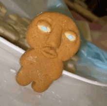 a gingerbread man with blue eyes is sitting on a white plate