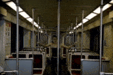 a woman stands in an empty subway car with her arms outstretched in front of a sign that says emergency exit