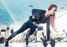 a woman is doing a plank exercise while holding a dumbbell with the number 10 on it