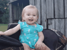 a little girl wearing a blue shirt with cats on it