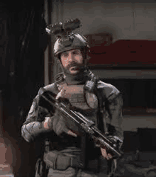 a soldier with a beard is holding a gun in a room .