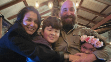 a family posing for a picture with a girl wearing a flower crown on her head