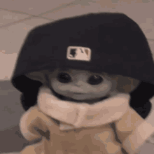 a baby yoda doll wearing a black hat