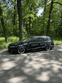 a black car is parked on the side of a road