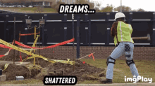 a construction worker is holding a hammer in front of a construction site with a sign that says dreams shattered