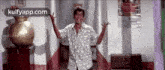 a man is standing in a hallway with his arms outstretched in a room .