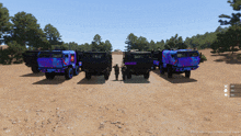 several military vehicles are parked on a dirt road with a soldier standing in front of them