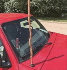 a red truck with a bunch of sausages attached to the windshield .