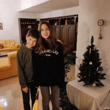 a boy and a girl are posing for a picture and the girl is wearing a los angeles sweater