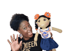 a woman holding a crocheted doll wearing a mets uniform