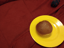 a yellow plate with a bun on it