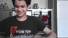 a boy wearing a black shirt that says 67 boxing team