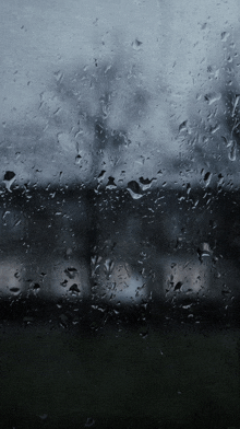 a window with rain drops on it and a dark background