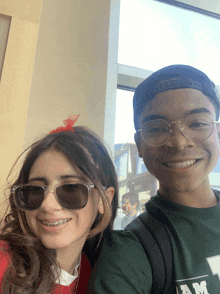 a boy and a girl are posing for a picture with the boy wearing a green shirt that says am