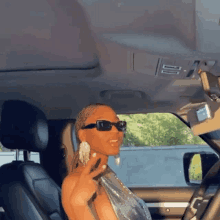 a woman wearing sunglasses is sitting in the back seat of a car .