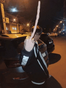 a man is giving the middle finger while standing next to a car