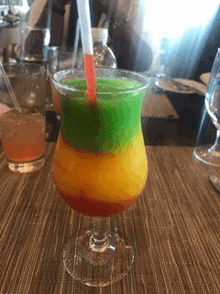 a colorful drink in a glass with a straw