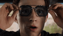 a close up of a man wearing glasses and making a surprised face