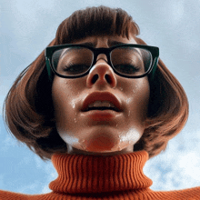 a woman wearing glasses and a turtleneck looks down at the camera