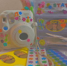 a white instax mini 8 camera surrounded by colorful stickers