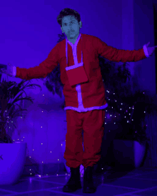 a man in a santa suit is standing in front of a blue light