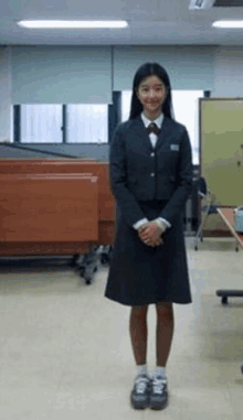 a girl in a school uniform is standing in front of a window