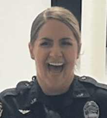 a close up of a woman in a police uniform smiling .