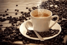 a cup of coffee is on a saucer surrounded by coffee beans .