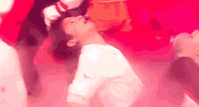 a man in a white shirt is dancing in a red room .