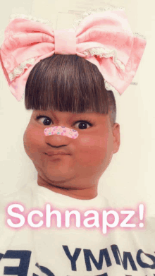 a person with a pink bow on their head and schnapz written on the bottom