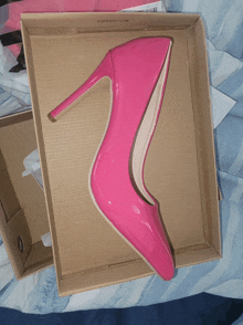 a pair of pink high heels in a box