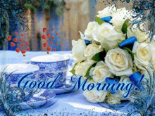 a bouquet of white roses sits on a table next to two cups of coffee and saucers and the words good morning