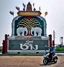 a man riding a scooter in front of a sign that says ' bangkok '