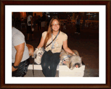 a woman is sitting on a bench with two small dogs on her lap